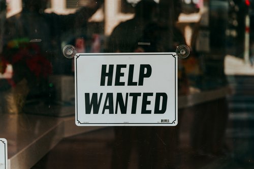 Ein Schild mit der Aufschrift "Hilfe gesucht" an einer Glastür